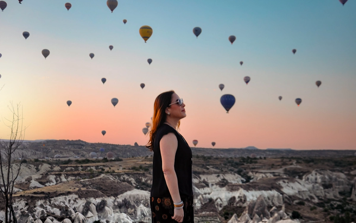 this is karen lee from more legs room chasing bucket list adventures and watching hot air balloons in the goreme valley in capadoccia turkiye during sunrise this is karen lee from more legs room chasing bucket list adventures and watching hot air balloons in the goreme valley in Cappadocia turkiye during sunrise